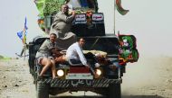 Iraqi federal police transport civilians, injured while opening a booby-trapped shop in Tayaran district of west Mosul, yesterday.