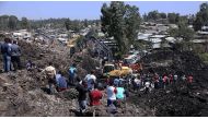 Rescue workers search for those buried by a landslide that swept through a massive garbage dump, killing at least 10 people and leaving several missing at Koshe rubbish tip in Kolfe Keranio district of Addis Ababa, Ethiopia on March 12, 2017. (Minasse Won