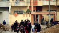 Displaced Iraqi families who fled from clashes during a battle between Iraqi forces and Islamic State militants, walk with their children in al-Sumood neighbourhood of Mosul, Iraq March 15, 2017. REUTERS/Thaier Al-Sudani
