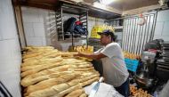 Members of a pro-government community organisation work in an expropriated bakery in Caracas on March, 17, 2017.  AFP / JUAN BARRETO
