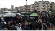 Syrian oppositions walk to get into a bus during an evacuation from the al-Waer neighborhood, in the western outskirts of the central city of Homs, Syria on March 18, 2017. ( Stringer - Anadolu Agency ).