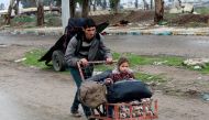 A displaced Iraqi carries his daughter in a cart to reach a safe area, as Iraqi forces battle with Islamic State militants, in the city of Mosul, Iraq March 18, 2017. REUTERS/Youssef Boudlal

