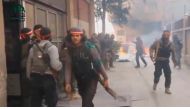 A still image taken from a video uploaded on social media on March 20, 2017, shows fighters, said to be members of Ahrar Al Sham group, walking near burning tyres, said to be in Damascus, Syria. Social Media Website via Reuters 