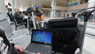 A Syrian woman travelling to the United States through Amman opens her laptop before checking in at Beirut international airport on March 22,2017.  AFP / ANWAR AMRO