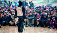 Civilians fleeing the city of Mosul sit under the rain yesterday as Iraqi forces advance in their massive operation to retake the second city from the Islamic State group. 