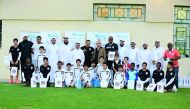 Dr Darwish poses for a group photo alongside famous football players – Abdulkarim Hassan, Al Sadd Sports Club player and Xavi Hernandez, Barcelona FC player – and other officials and students during an event held at the Al Sadd Sports Club to mark the Wor