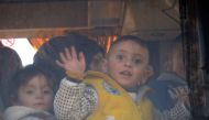 (File Photo) A child waves from the window of a bus as Syrians who were evacuated from Waer, the last opposition-held district of Homs, arrive in the northern Syrian town of al-Bab on March 19, 2017, under a controversial Russian-supervised deal to bring 