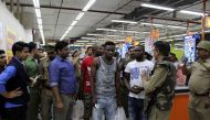 This photo taken on March 27, 2017 shows Indian police and onlookers surrounding African nationals at a shopping mall in Greater Noida. AFP 