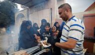 An Iraqi volunteer (R) gives food to displaced people during a battle with Islamic State militants in Mosul, Iraq March 28, 2017. REUTERS/Khalid al Mousily