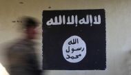 An Iraqi forces member walks past a wall painted with the black flag used by Islamic State militants at a hospital damaged by clashes in the Wahda district of eastern Mosul, January 8, 2017 (REUTERS) 