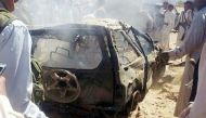 Yemenis gather around a burned car after it was targeted by a drone strike killing three suspected Al-Qaeda militants on Jan. 26, 2015 between the Marib and Chabwa provinces, a desert area east of Sanaa. AFP PHOTO / STR.