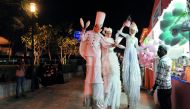 Stilt walkers entertaining visitors at the Qatar International Food Festival at Hotel Park, yesterday.  Pic: Kammutty V P / The Peninsula