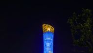 The Torch Doha illuminated in blue.