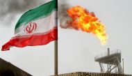 FILE PHOTO: A gas flare on an oil production platform in the Soroush oil fields is seen alongside an Iranian flag in the Persian Gulf, Iran July 25, 2005. REUTERS/Raheb Homavandi/File Photo.