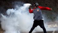 A demonstrator throws a tear gas canister back at the police during a protest against Venezuelan President Nicolas Maduro's government in San Cristobal, Venezuela April 5, 2017. REUTERS/Carlos Eduardo Ramirez
