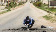 A Syrian man collects samples from the site of a suspected toxic gas attack in Khan Sheikhun, in Syria's northwestern Idlib province, on April 5, 2017. AFP / Omar haj kadour

