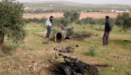 Men inspect a piece of a rocket that landed south of Daraa Al-Balad, Syria, April 5, 2017. REUTERS/Alaa Al-Faqir.