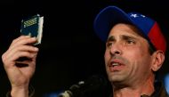 Venezuelan opposition leader and former presidential candidate Henrique Capriles holds a copy of the constitution during a press conference in Caracas on April 7, 2017. AFP / FEDERICO PARRA