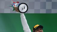Mercedes' British driver Lewis Hamilton raises the trophy after winning the Formula One Chinese Grand Prix as he celebrates on the podium in Shanghai on April 9, 2017. / AFP / WANG ZHAO