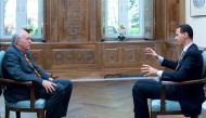 A handout picture released by the Syrian presidency's press office shows Syrian President Bashar al-Assad (R) during an interview with AFP's Beirut bureau chief Sammy Ketz in the capital Damascus, on April 12, 2017. / AFP / Syrian Presidency Press Office 