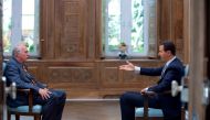 A handout picture released by the Syrian presidency's press office shows Syrian President Bashar al-Assad (R) during an interview with AFP's Beirut bureau chief Sammy Ketz in the capital Damascus, on April 12, 2017. / AFP / Syrian Presidency Press Office 