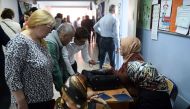 People and electoral officials are seen at a polling station as the country votes in the referendum on expanding the powers of the Turkish president on April 16, 2017 in Istanbul. AFP / OZAN KOSE