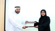 Dr Mohamed Abdulaziz Al Khulaifi, Dean of the College of Law, and Fatima Abdulaziz Bilal, Director of the Legal and Judicial Studies Centre, exchanging the documents. 