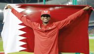 Mutaz Barshim with Qatar flag after winning the silver medal in the high jump event at the Rio Olympic Games in this August 2016 file picture.