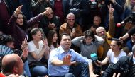 Albanian opposition leader Lulzim Basha gestures as he together with his supporters sit in the middle on a main artery of the capital to block traffic for one hour as they escalate their protest in Tirana on April 24, 2017.  AFP / Gent Shkullaku