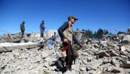 Fighters from the Kurdish People's Protection Units (YPG) visit the site of Turkish airstrikes near northeastern Syrian Kurdish town of Al-Malikiyah on April 25, 2017 (AFP Photo/DELIL SOULEIMAN).