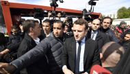 French presidential election candidate for the En Marche ! movement Emmanuel Macron arrives outside Whirlpool factory outside the Amiens Cathedral on April 26, 2017.   AFP / POOL / Eric FEFERBERG
