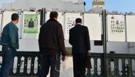 Algerian men look at electorial campaign posters for the upcoming legislative elections in Algiers' Martyrs Square as the official start of campaigning got underway on April 9, 2017.Ryad Kramdi/AFP