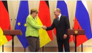 German Chancellor Angela Merkel (L) and Russian president Vladimir Putin (R) shake hands during a press conference after their meeting in Sochi, Russia on May 2, 2017. ( Nataliy Zemboska - Anadolu Agency ).