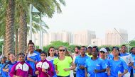Australia's Genevieve Lacaze (centre) runs with schoolchildren during the inspiring event at MIA Park 