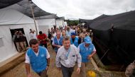 This handout picture released by the UN press office show Uruguay's ambassador at the UN Elbio Rosselli (C) and members of the United Nations Security Council upon arrival at the Transitional Standardization Zone in La Reforma municipality, Meta departmen