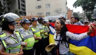 A demonstrator shouts slogans in front of police officers during a women's march to protest against President Nicolas Maduro's government in Caracas, Venezuela May 6, 2017. REUTERS/Carlos Garcia Rawlins