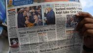 An Indian man reads a newspaper with the front page news of Emmanuel Macron winning the French Presidential elections in Mumbai on May 8, 2017. AFP / INDRANIL MUKHERJEE