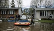 A resident of Ile Mercier south of Quebec pulls a rubber boat in the floods on Saturday 6, 2017.  ( Amru Salahuddien - Anadolu Agency )