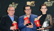 Director Bill Condon (L) stands with actors Josh Gad (C) and Emma Watson (R), winners of Movie of the Year for 'Beauty and the Beast' in the press room during the 2017 MTV Movie & TV Awards at the Shrine Auditorium in Los Angeles, California, May 7, 2017.