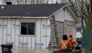 Hydro-Quebec workers check on evacuated homes in a flooded residential neighbourhood in Rigaud, Quebec, Canada May 7, 2017. REUTERS/Christinne Muschi
