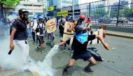 Opposition supporters clash with riot police during a rally against President Nicolas Maduro in Caracas, yesterday.