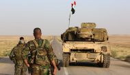 Syrian government forces secure a road for a military convoy in the desert area of Saba' Biyar, in southeastern Syria near the border with Iraq, on May 10, 2017, as fierce clashes are reported in the region. / AFP 