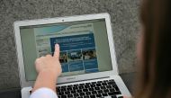 In this posed picture photograph, a woman points to the website of the NHS: East and North Hertfordshire notifying users of a problem in its network, in London on May 12, 2017. AFP / Daniel Leal-Olivas