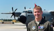 US Airforce meteorologist Garrett Black poses for a photo in front of US Air Force Hurricane Hunter WC-130 reconnaissance aircraft at the Coast Guard Air Station at Opa Locka Airport on May 12, 2017 in Miami, Florida. The aircraft is part of NOAA's Hurric