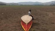 A boy sits on an abandoned boat on what is left of Lake Atescatempa, which has dried up due to drought and high temperatures, in Atescatempa, 174 km southeast of Guatemala City, on May 5, 2017. AFP / Marvin RECINOS