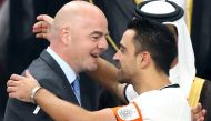 Al-Sadd's Spanish capitan Xavi (R) is embraced by FIFA President Gianni Infantino during the presentation of the trophy following the Qatar Emir Cup Final football match between Al-Sadd and Al-Rayyan at the Khalifa International Stadium in Doha on May 19,