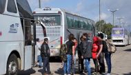 Syrian opposition fighters and their families arrive at a checkpoint manned by regime forces ahead of their evacuation from Waer neighbourhood, the last opposition-held district in the central city of Homs, on May 20, 2017. / AFP / STRINGER
