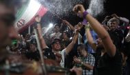 Supporters of newly re-elected Iranian President Hassan Rouhani dance during a gathering to celebrate his victory at the Vanak square in downtown Tehran on May 20, 2017 (AFP Photo/Behrouz MEHRI).