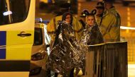 Two women wrapped in thermal blankets stand near the Manchester Arena, where U.S. singer Ariana Grande had been performing, in Manchester, northern England, Britain, May 23, 2017. REUTERS/Andrew Yates