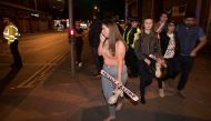 Concert goers react after fleeing the Manchester Arena in northern England where U.S. singer Ariana Grande had been performing in Manchester, Britain, May 22, 2017. REUTERS/Jon Super